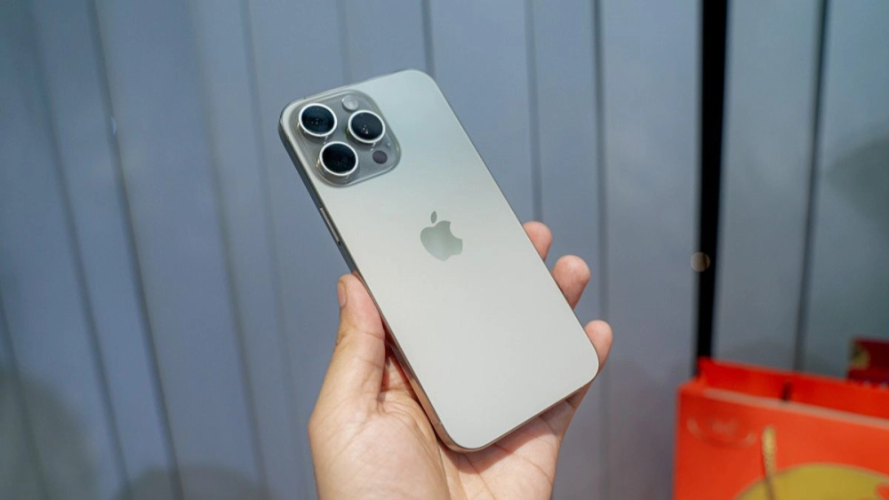 iPhone 15 Pro Max với khung titan sang trọng, màu Titan Tự Nhiên dưới ánh sáng.